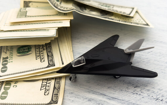  toy airplane fighter bomber on US dollar bill banknotes background. fights against terrorism or sells arms weapons to other countries concept.