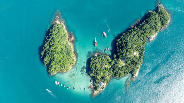 Aerial view of Lagoa Azul with turquoise water, lush green islands, and small boats anchored in the bay in Angra dos Reis, Rio de Janeiro, Brazil.