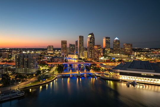 Downtown district of Tampa city in Florida, USA after sunset. Brightly illuminated highway bridge and high buildings in modern American urban area.
