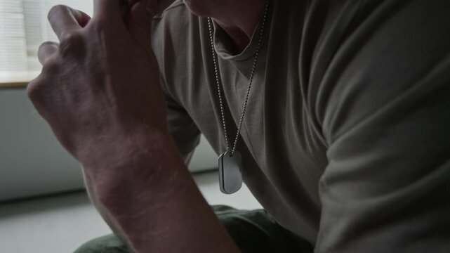 Caucasian male veteran wearing dog tags crying and covering face in emotional distress. Footage for mental health awareness campaigns and veteran support services