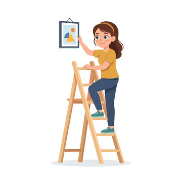 Woman climbing ladder to hang a picture indoors with a smile  