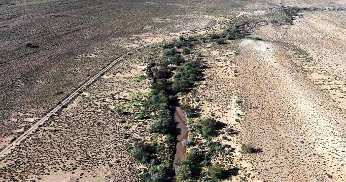 Drone aerial view of a seasonal river cutting through the semi-arid Great Karoo near Prince Albert in the Western Cape, South Africa. Beautiful with the surrounding dry plains and expansive wilderness