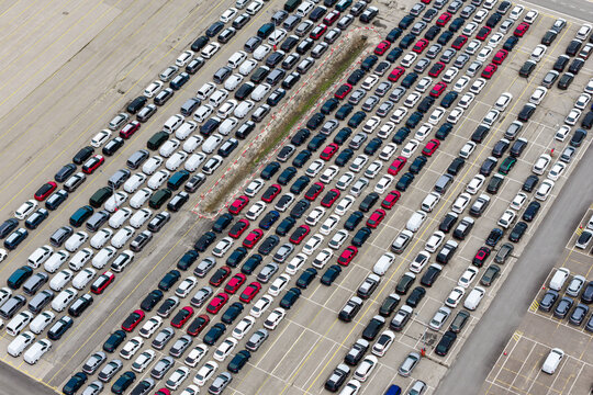 Aerial view of a large parking lot filled with numerous new cars arranged in neat rows at a car forwarding company in Poland.