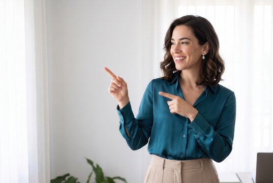 Smiling woman pointing towards copy space, presenting an idea or offer