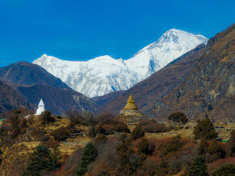 Aerial view of Buddhist stupas set against the snow-capped Himalayan mountains in Nepal.