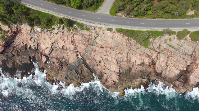 Ninety degrees down aerial view of coastline road and cliffs