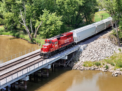 Savanna, Illinois June 22, 2026 Canadian Pacific 2326 locomotive in bright red livery on mainline track crossing a cement bridge pulling freight.