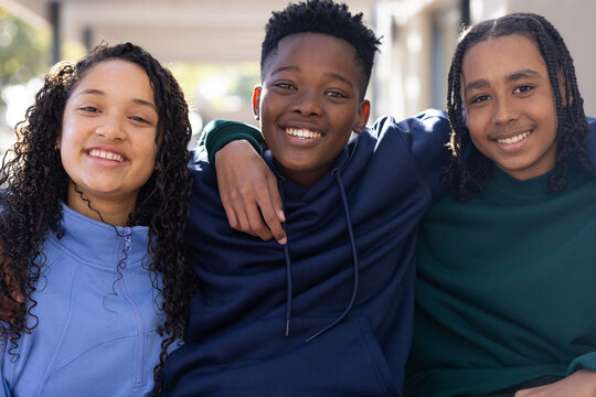 African American teen friends smiling at school in hoodies and zip-up jacket showing drawstrings