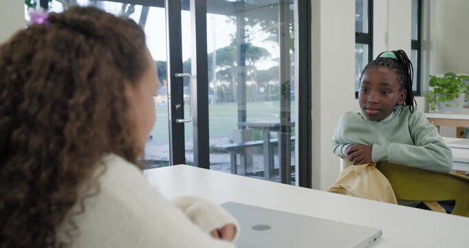 African American teen girls sitting at table near doors left speaking right smiling with yellow bag