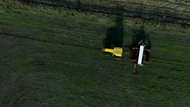 Maquinaria agr&iacute;cola trabajando en un campo vista desde un drone