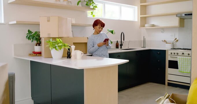 Phone alert drawing African American woman in kitchen, scrolling phone, unpacking boxes, copy space