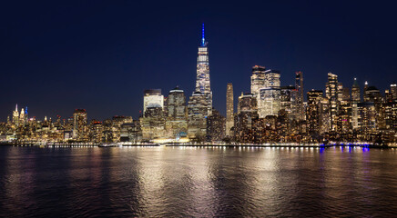Fototapeta premium New York City panoramic night view of Manhattan. New York skyline at night. NYC night metropolis skyline view. New York as a big American city. New York City glowing at night.