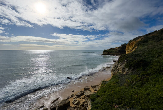 Aerial seascape and coastline cliffs of Praia do Barranco das Belharucas beach, in Algarve region in South Portugal. Praia do Barranco das Belharucas beach, Albufeira, Algarve, Portugal.
