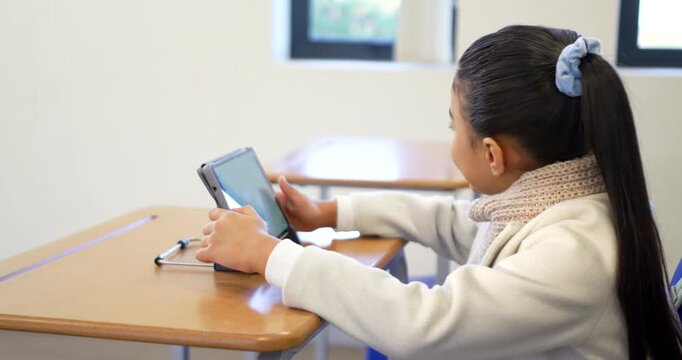 African American child placing tablet case on school desk stylus near tapping screen leaning closer