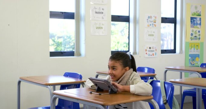 Girl child student tapping tablet stand front class glancing up raising hand to teacher, copy space