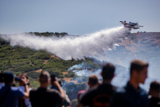 Firefighting Aircraft Battling Derveni Wildfire as Onlookers Observe the Operation
