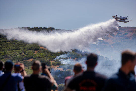 Firefighting Aircraft Battling Derveni Wildfire as Onlookers Observe the Operation