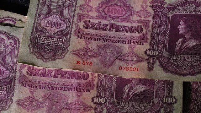 Top Down View of Vintage Hungarian Pengo Banknotes Dropping on Dark Fabric Rotating on Turntable