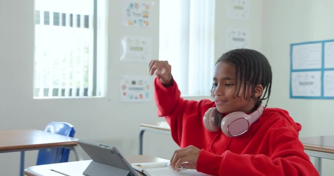 African American teen in hoodie raising hand seeking help, tapping tablet, writing notebook at desk