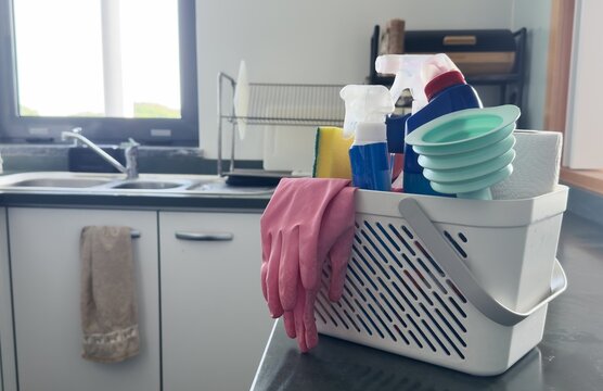 Different cleaning supplies in basket on table