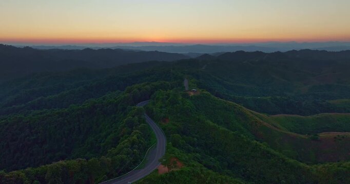 Aerial view of the legendary number three curve road in Nan, a scenic mountain highway known for its dramatic serpentine bends surrounded by green forest and panoramic landscapes.