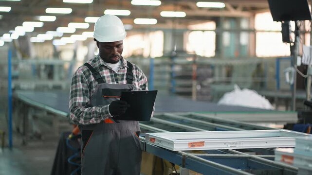 Factory worker performing quality control on a pvc window frame