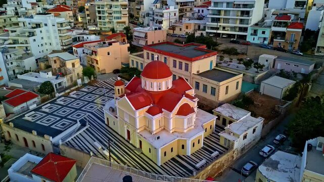 Aerial view of the Metropolitan Cathedral of Agios Minas with its distinctive red domes and patterned courtyard in Heraklion, Greece.