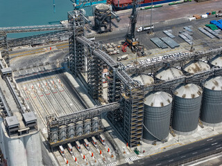 Grain port terminal with vertical steel silos and conveyors seen from above, maritime logistics © WILL PHOTOGRAPHY