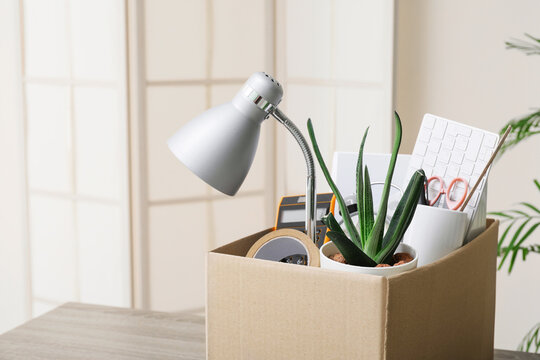 Cardboard box filled with personal office items, job loss, relocation, or a new beginning