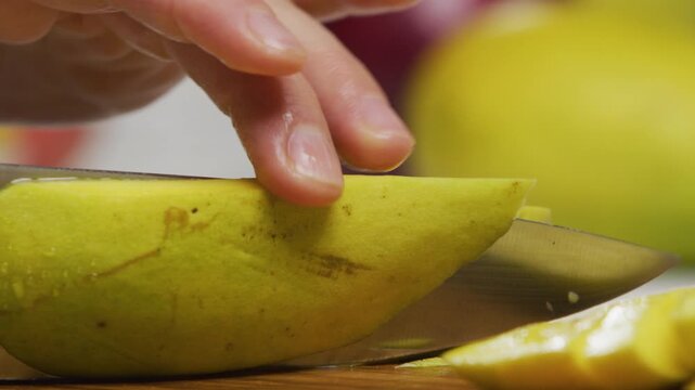 Extreme closeup of delicious mango being sliced and squared in slow motion