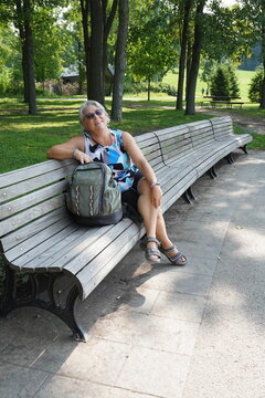 retired senior woman sitting on a park bench