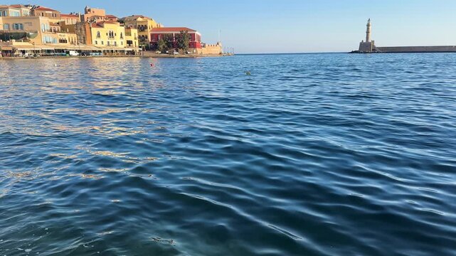 bay of Chania with sea and lighthouse at sunny summer sunset, Crete, Greece,