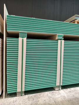 Gypsum plasterboards neatly arranged in rows within a construction warehouse