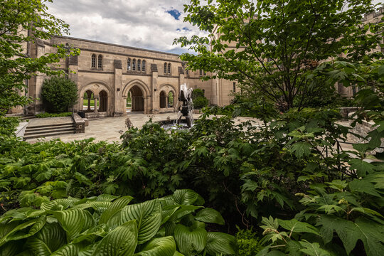 Washington, District of Columbia, United States - 06 May 2025: View of the Bishop's Garden fountain at Washington National Cathedral, with lush foliage and stone archways.