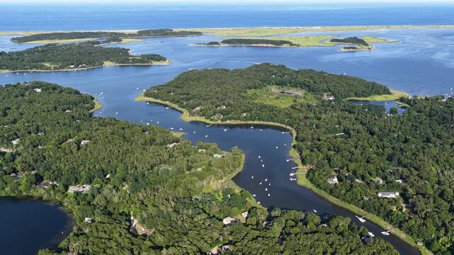 Healthy forest and marsh surrounds the scenic Arey's Pond in Orleans, Cape Cod, MA. This area of New England is a perfect area for sailboats during the warm summer months.