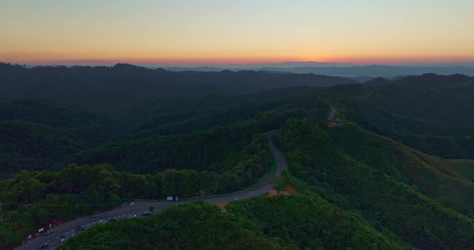Aerial view of the legendary number three curve road in Nan, a scenic mountain highway known for its dramatic serpentine bends surrounded by green forest and panoramic landscapes.
