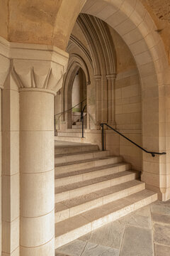 Washington, United States - 06 May 2025: View of the stone archway and stairs inside the Washington National Cathedral, featuring Gothic architectural details and metal handrails.