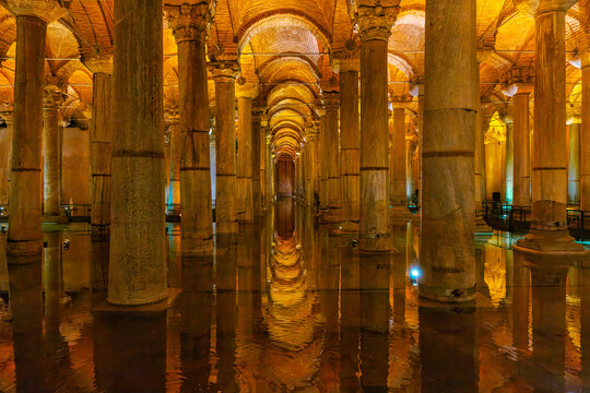 Fatih, Turkiye - 26 July 2026: View of the Basilica Cistern with its rows of ancient marble columns reflected in the calm water under warm golden lighting.