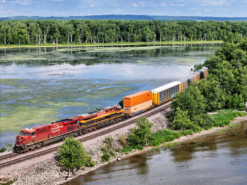 Savanna, Illinois June 23, 2026 Canadian Pacific 8893 GE locomotive in red livery pulling freight along the Mississippi river.