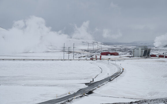 Krafla geothermal power plant releasing steam in a snow covered winter landscape, showcasing renewable energy production. Iceland icelandic landscape