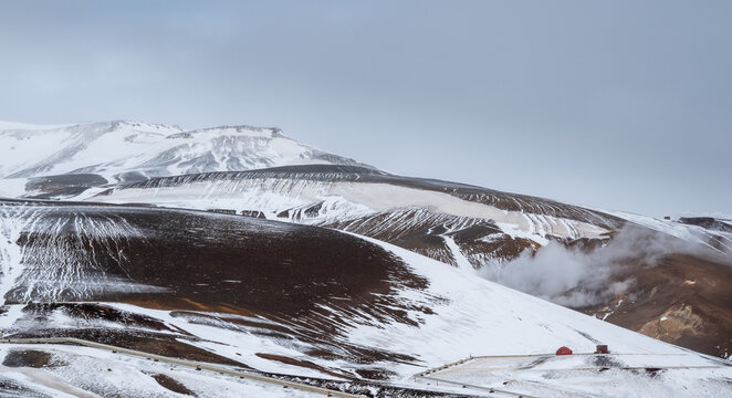 Krafla power plant creating renewable energy from geothermal steam in a snowy, volcanic iceland landscape