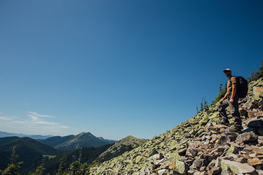 Tourist with a backpack in the mountains watching a beautiful view