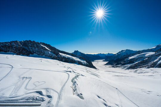 Aletsch Glacier sweeping valley with sunburst. Jungfraujoch, Canton of Bern, Switzerland.