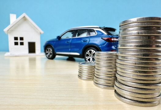 House model, blue car, stacked coins, mortgage investment, auto loan, property finance, wealth growth, real estate savings, cash money, bank concept, home buying, budget planning, financial security.