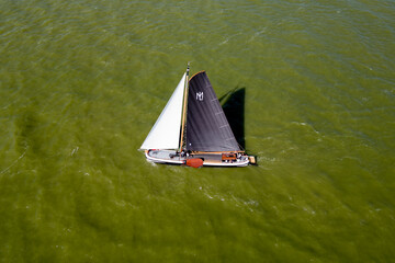 Fototapeta premium STAVOREN, THE NETHERLANDS AUGUST 12, 2023: Traditional Skutsjes Compete During the Annual SKS Skutsjesilen Sailing Championship on the IJsselmeer