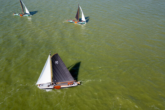 STAVOREN, THE NETHERLANDS AUGUST 12, 2023: Traditional Skutsjes Compete During the Annual SKS Skutsjesilen Sailing Championship on the IJsselmeer