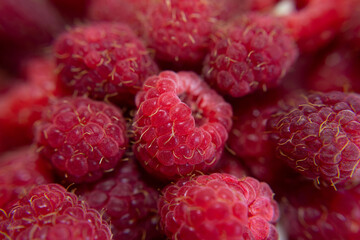 Macro close-up of fresh ripe raspberries with vivid red color and detailed drupelets, highlighting juicy texture, natural freshness, healthy nutrition and seasonal berry appeal © Photolove