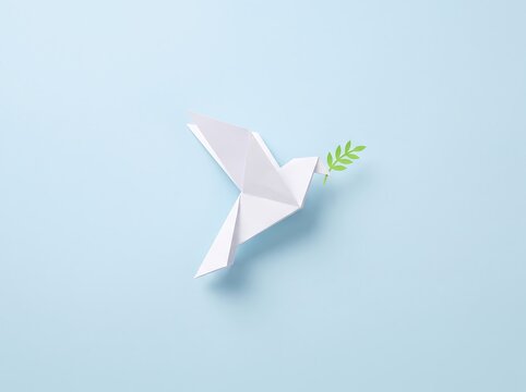 A white paper origami bird holding a small green leaf on a light blue background