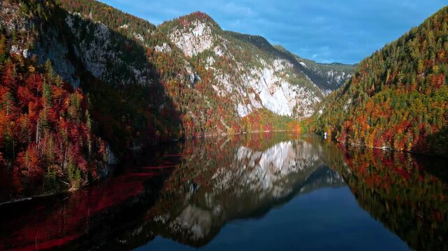 Aerial view of Attersee with autumn foliage on the surrounding mountains and calm water reflecting the landscape in Vocklabruck District, Upper Austria, Austria.