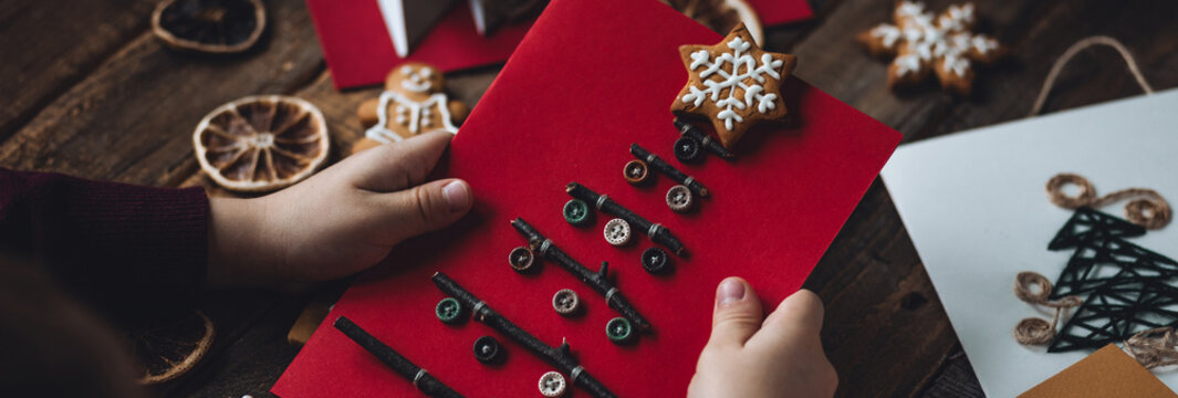Banner. Concept of christmas leisure, family time, original do it yourself present. Little boy holding handmade card made with recyclable natural materials, zero waste, sustainable lifestyle, hobby.